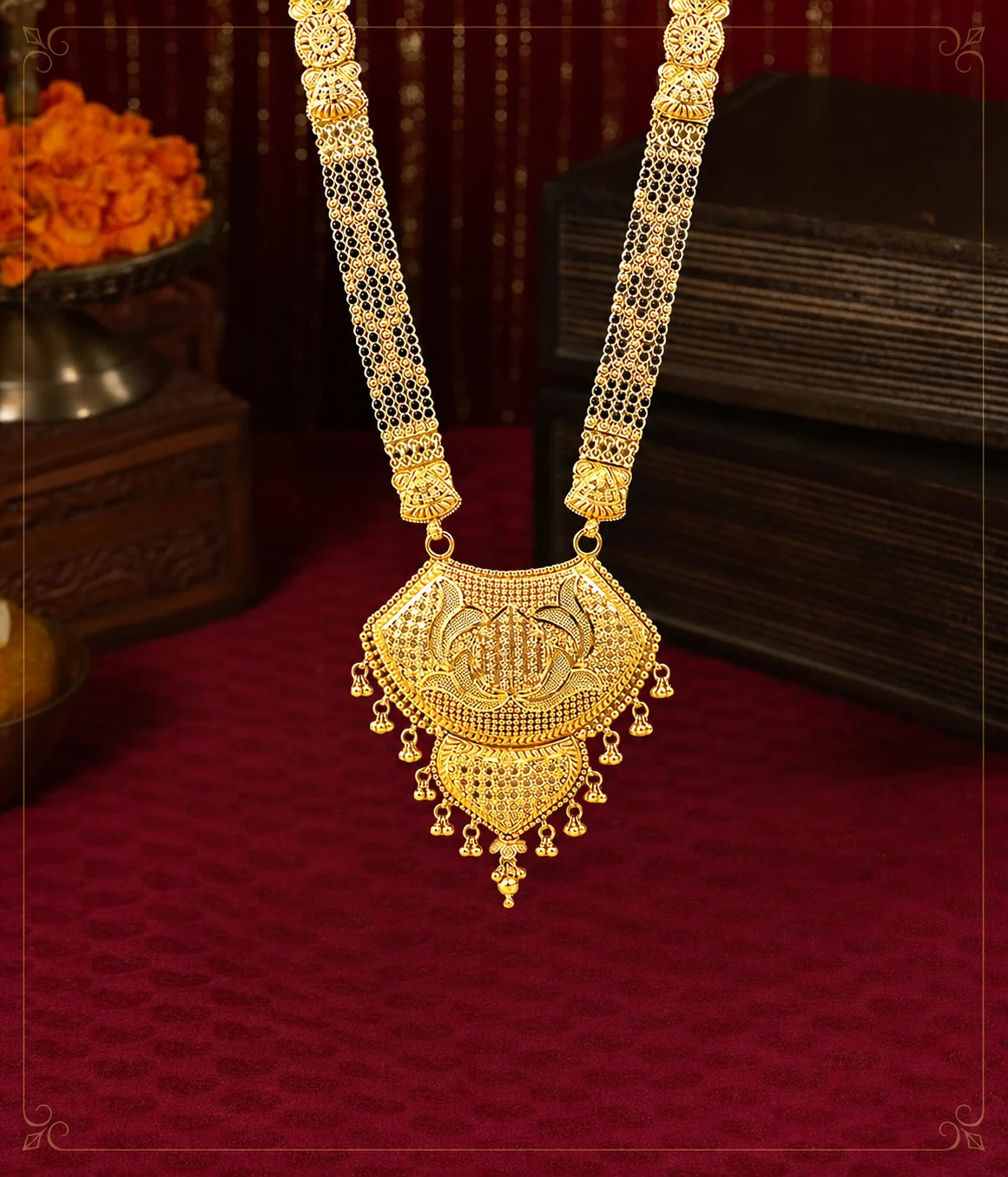 Delicate gold pendant necklace displayed against maroon velvet
